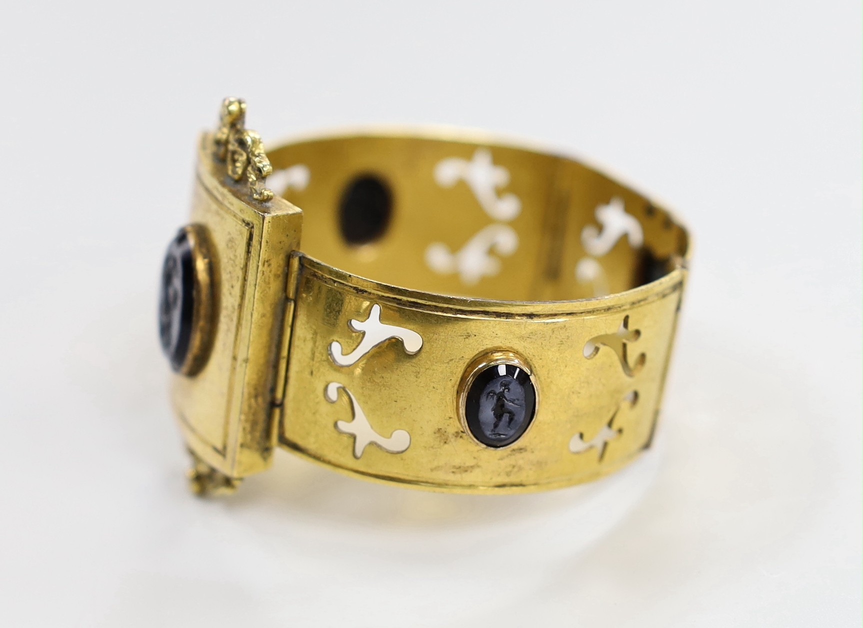 A Victorian gilt metal and four stone glass intaglio set bracelet, (repair), each stone carved with a cherub, 15cm.